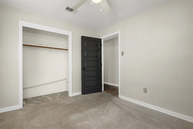 an empty room with closet and mirror