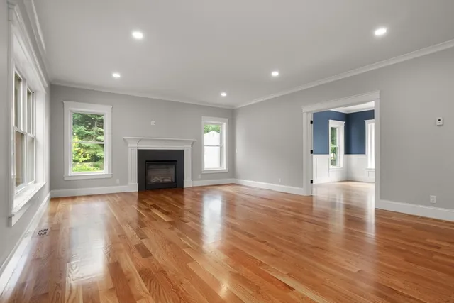 an empty room with wooden floor and fireplace