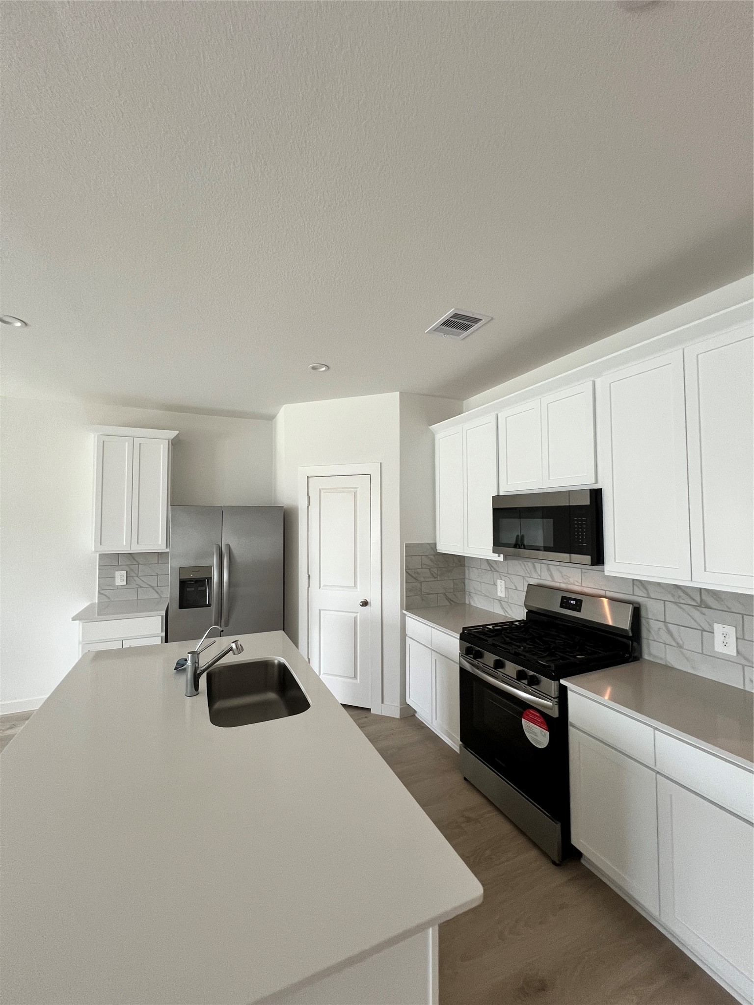 3811 Winterbourne Way Fulshear, TX 77441 - Photo 5 of 22 a kitchen with kitchen island a sink a stove and refrigerator