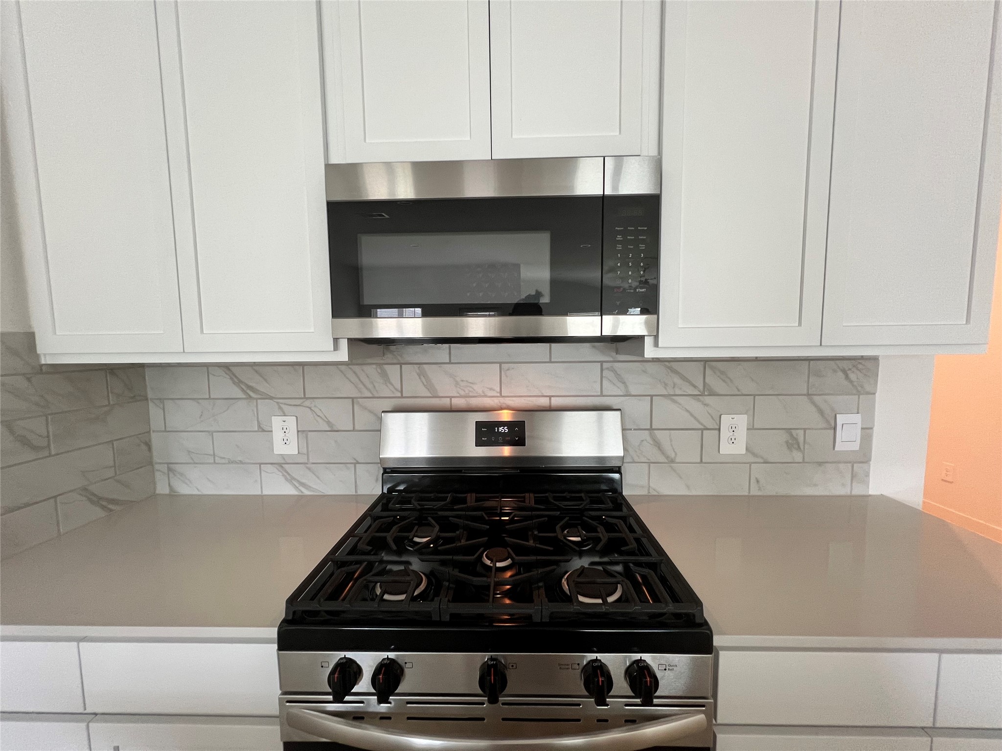 3811 Winterbourne Way Fulshear, TX 77441 - Photo 8 of 22 a kitchen with a stove and white cabinets