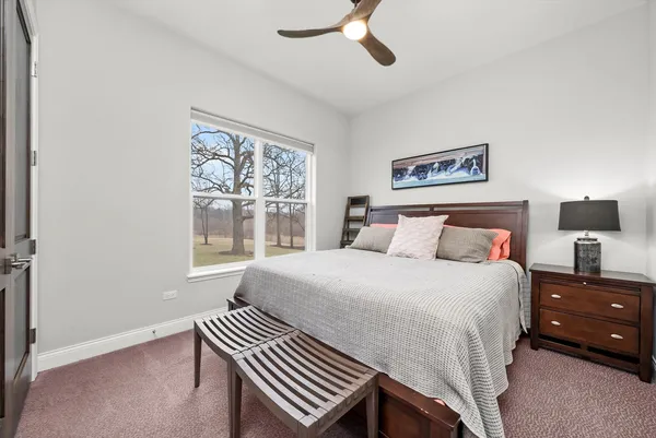 a spacious bedroom with a bed a couch and a chandelier