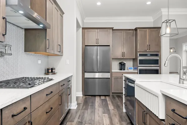 a kitchen with stainless steel appliances kitchen island granite countertop a stove a sink and a refrigerator