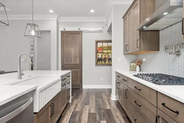 a kitchen with a table chairs refrigerator and cabinets