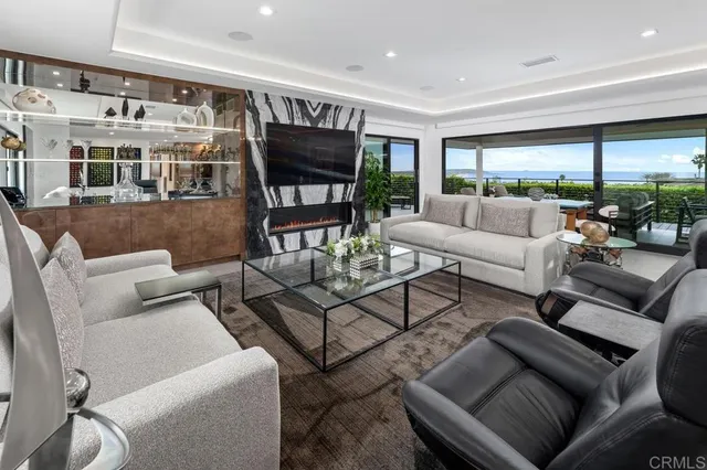 a living room with patio furniture and a garden