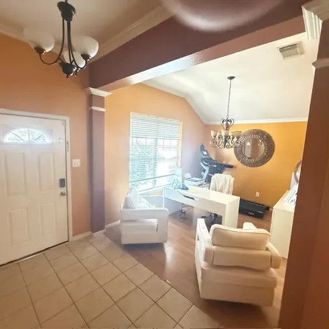 a living room with furniture and a chandelier
