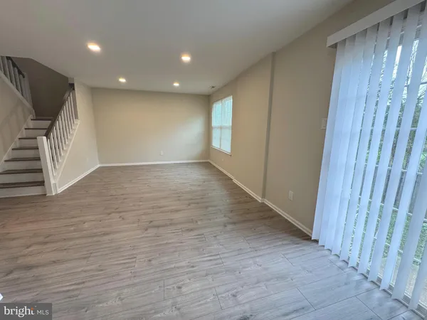 an empty room with wooden floor and staircase