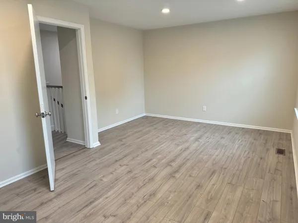 an empty room with wooden floor and entrance