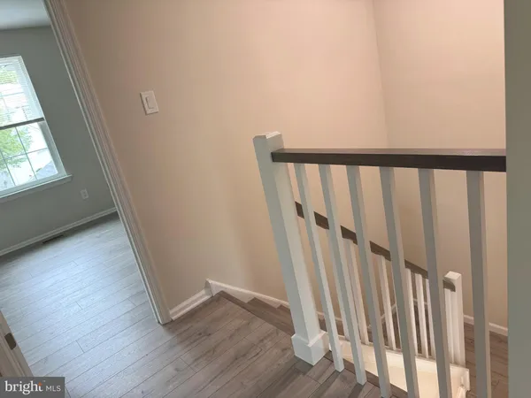 a view of a hallway with wooden floor and staircase