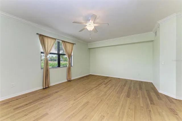 an empty room with a window and wooden floor