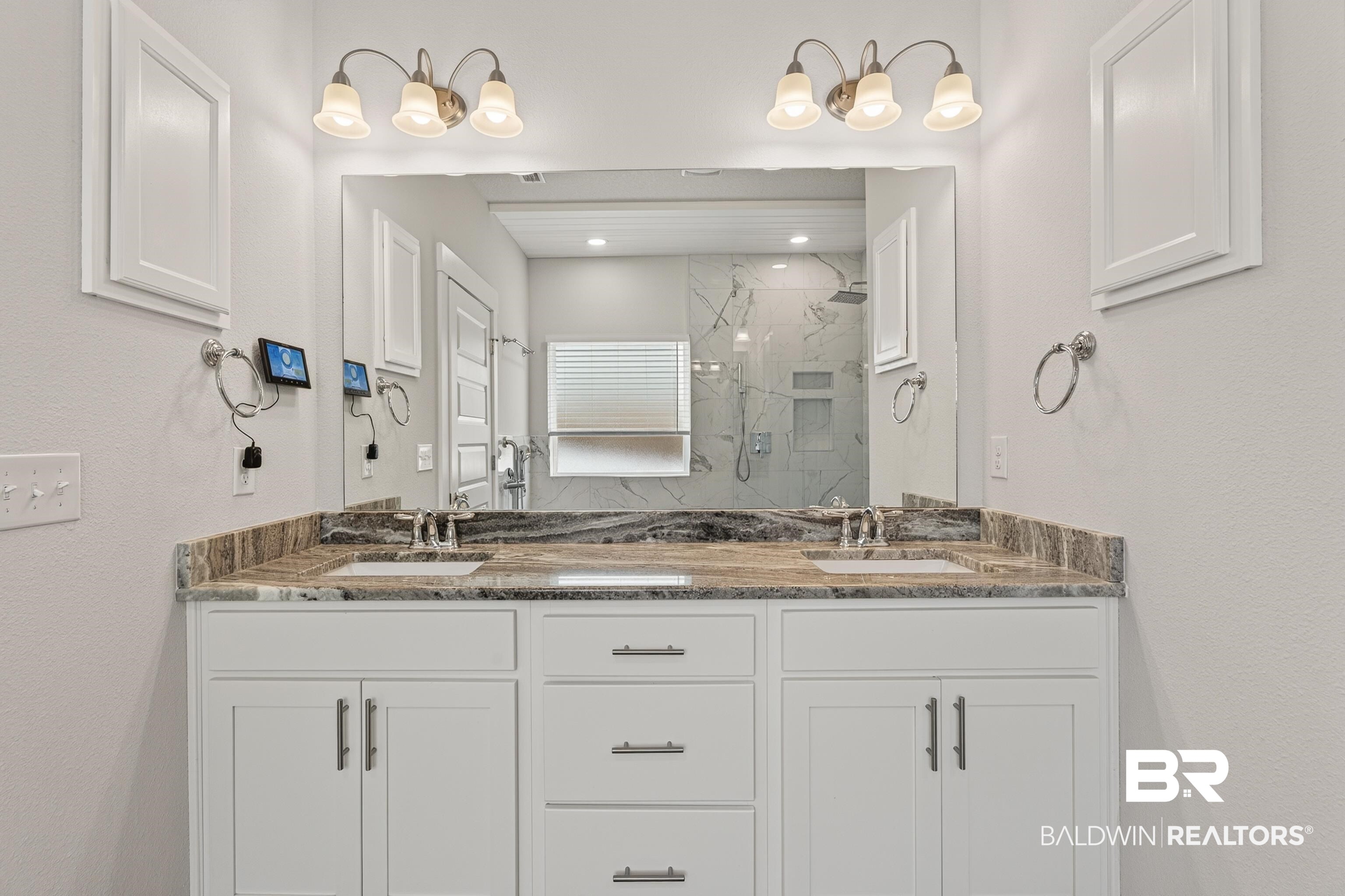 1724 Partridge Street Foley, AL 36535 - Photo 33 of 62 Double vanity featuring dual undermount sinks, granite countertops, and white shaker-style cabinetry