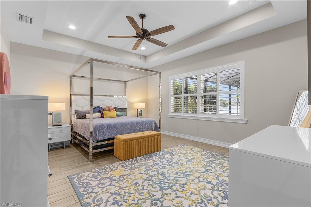 14539 Kelson Circle Naples, FL 34114 - Photo 13 of 37 Primary Bedroom featuring a raised ceiling, wood tiled floors, ceiling fan, and recessed lighting