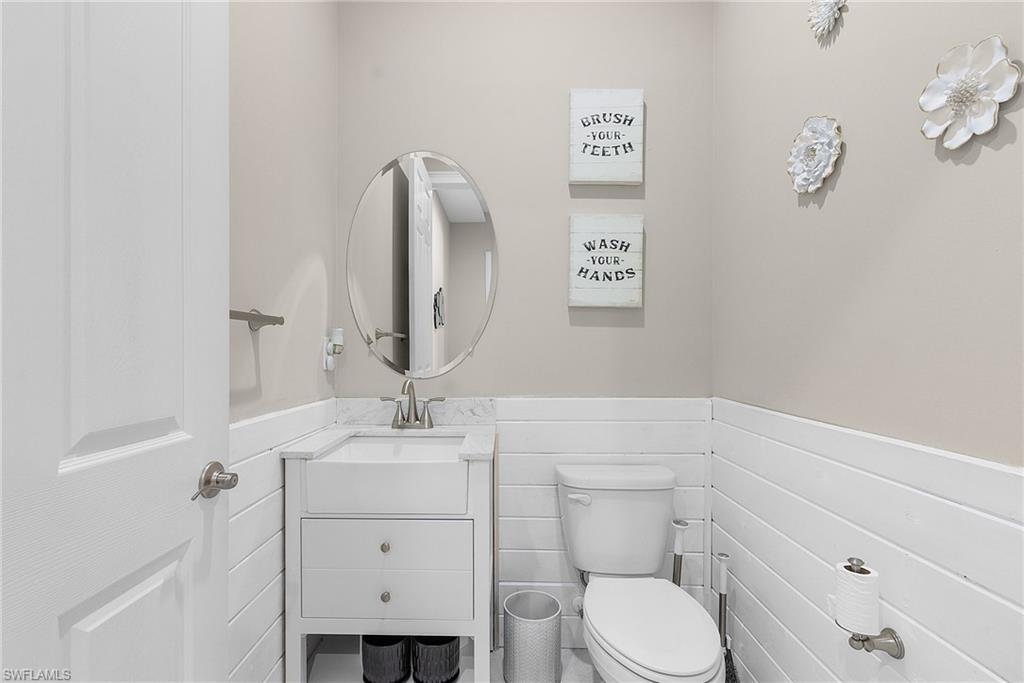 14539 Kelson Circle Naples, FL 34114 - Photo 20 of 37 Downstairs half bathroom with wainscoting and vanity