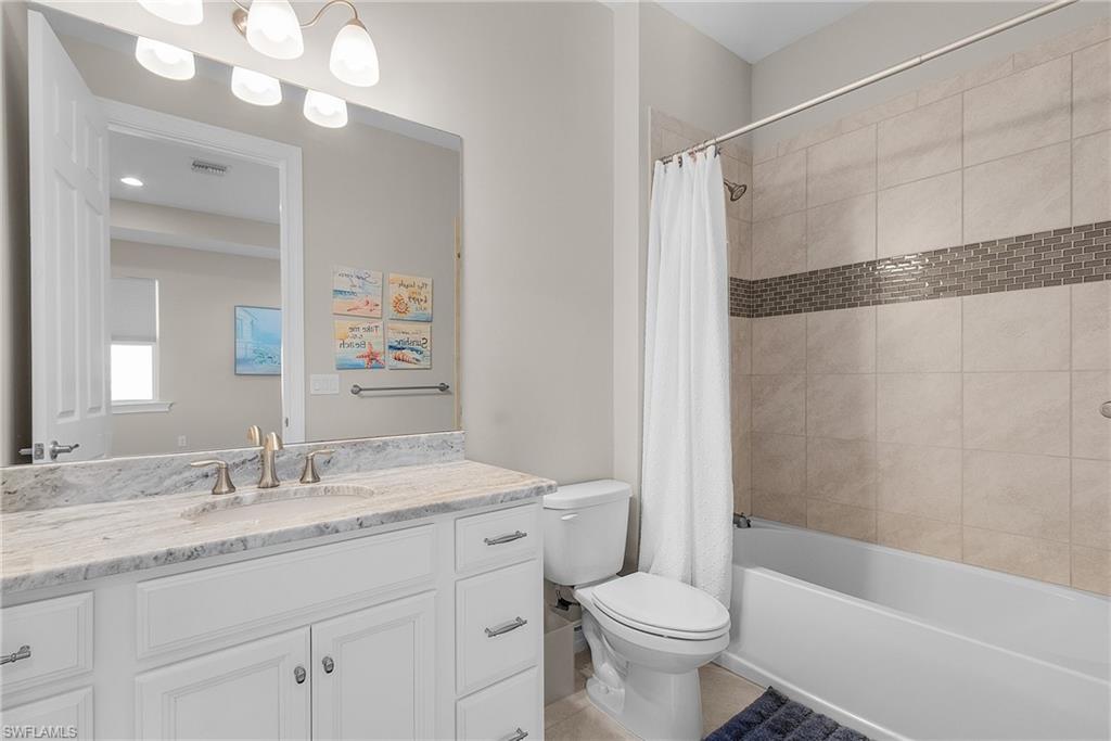 14539 Kelson Circle Naples, FL 34114 - Photo 26 of 37 Upstairs Full bathroom featuring shower / bath combination with curtain, vanity, and light tile patterned floors