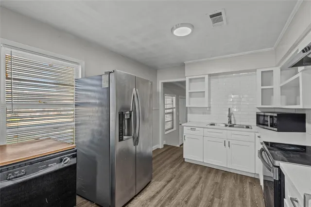 a kitchen with stainless steel appliances a refrigerator sink and cabinets