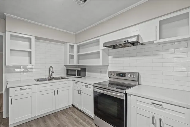 a kitchen with cabinets stainless steel appliances and a sink