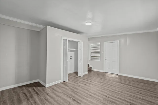 a view of an empty room with wooden floor