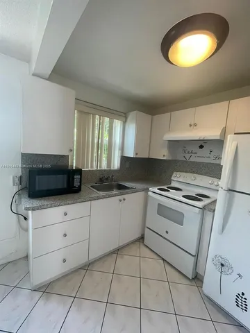 a kitchen with a stove a sink and a refrigerator