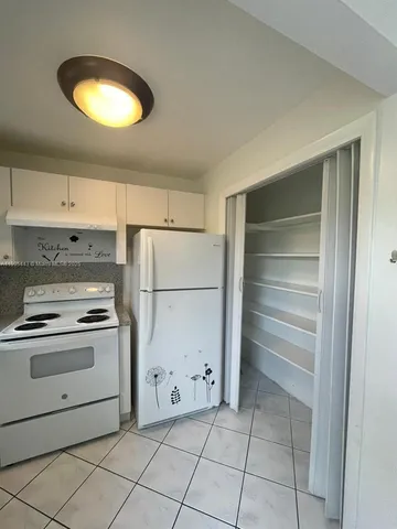 a kitchen with white cabinets and white appliances