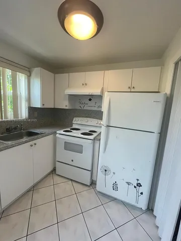 a kitchen with cabinets appliances and a window