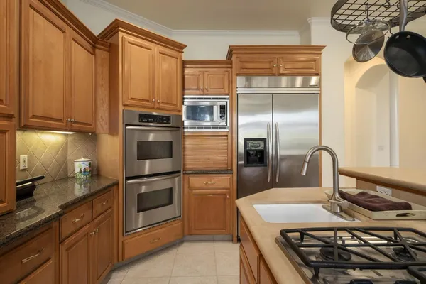 a kitchen with stainless steel appliances granite countertop a refrigerator a stove a sink and a microwave