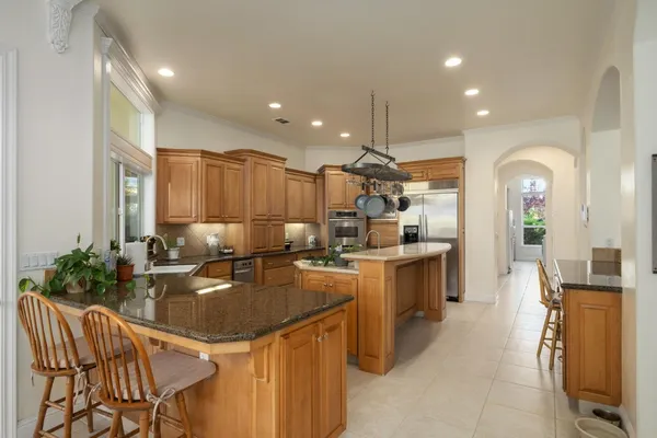 a kitchen with kitchen island granite countertop lots of counter top space and stainless steel appliances