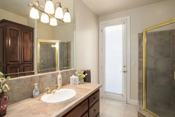 a bathroom with a sink vanity granite shower and a mirror