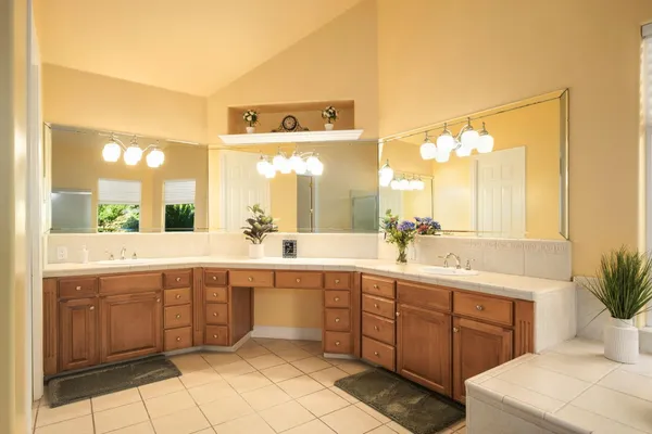 a spacious bathroom with a granite countertop sink a mirror and a bathtub