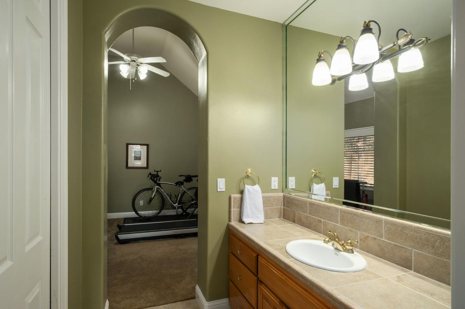 3386 East Vía Monte Verdi Clovis, CA 93619 - Photo 33 of 51 a bathroom with a sink and a mirror