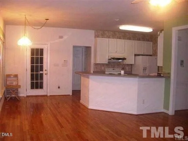 a kitchen with kitchen island granite countertop wooden floors and wide window