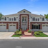 a front view of a house with a garden and trees