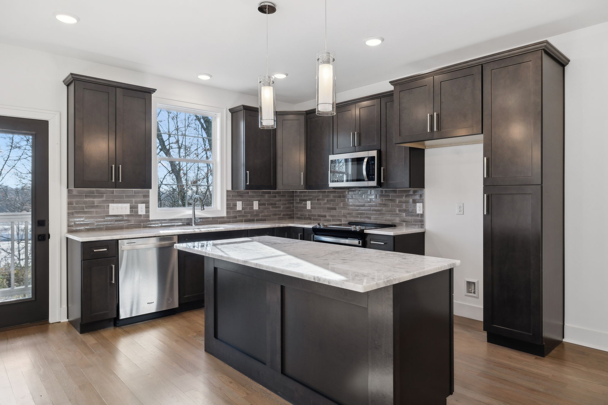 a kitchen with stainless steel appliances granite countertop a sink a stove a refrigerator and island with wooden floor