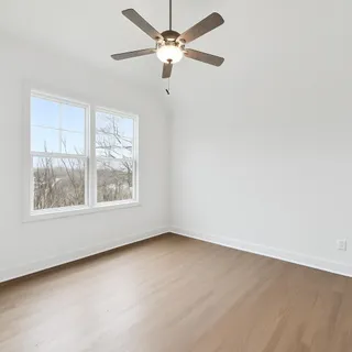 an empty room with a window and a fan