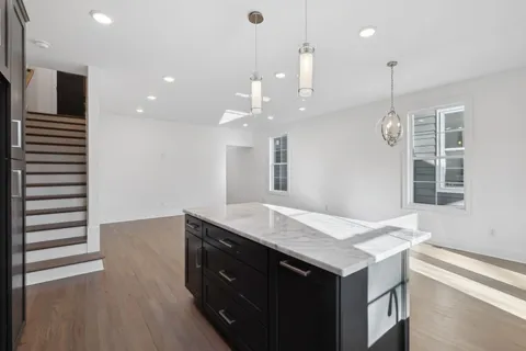a kitchen with a sink chandelier and wooden floor