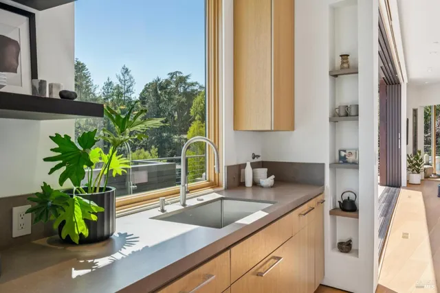 a large kitchen with granite countertop a stove a sink a dining table and chairs