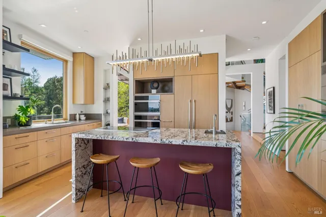 a living room with furniture wooden floor and a large window
