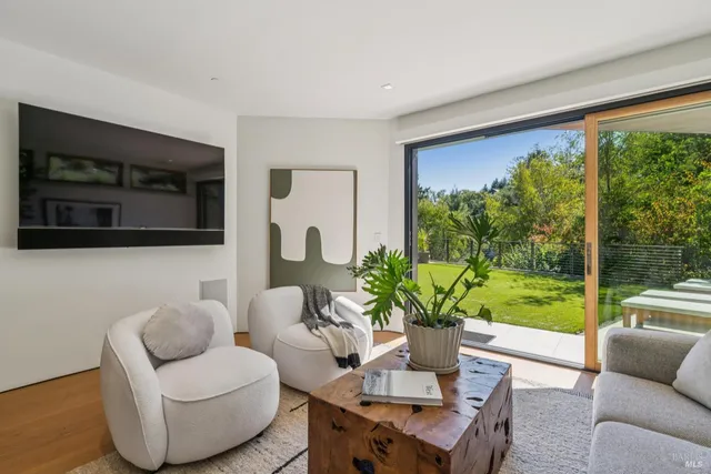 a view of a patio with couches and chairs with wooden floor