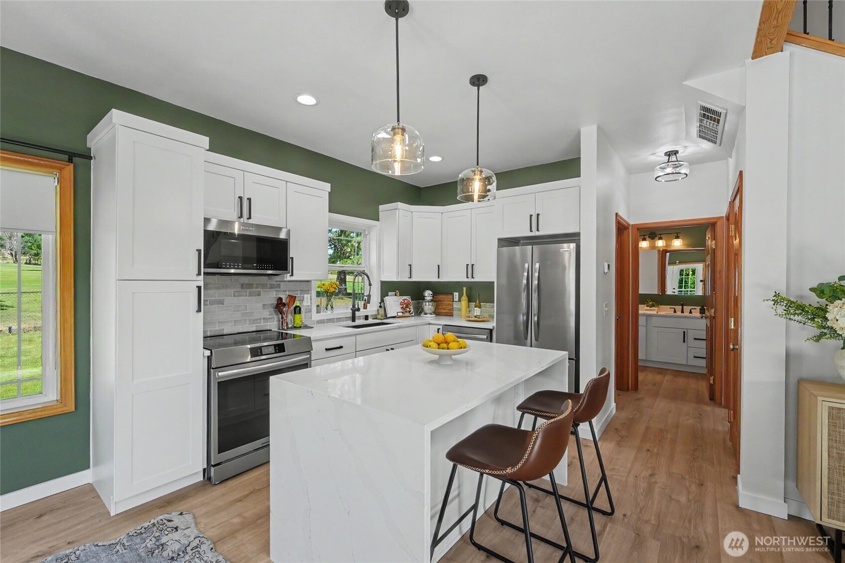 93 Golf Course Drive Pateros, WA 98846 - Photo 5 of 34 a kitchen with stainless steel appliances a stove a refrigerator a oven a sink a stove and white cabinets with wooden floor
