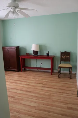 a view of a room with wooden floor and furniture