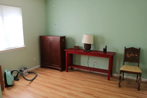 a room with gym equipment and wooden floor