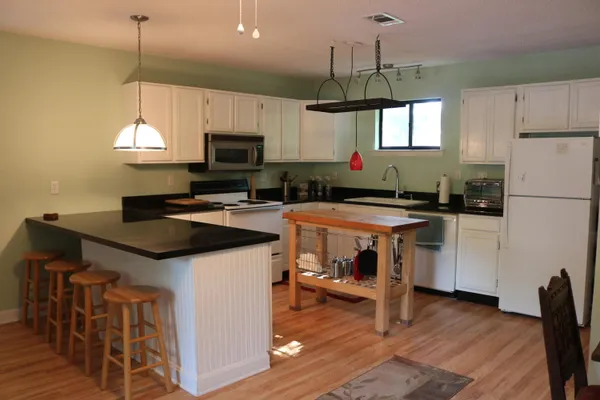 a kitchen with granite countertop a sink a counter top space cabinets and stainless steel appliances