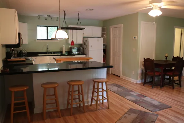 a kitchen with a table chairs refrigerator and cabinets