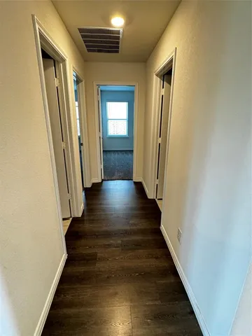 a view of a hallway with wooden floor and staircase