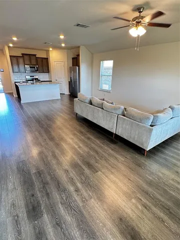 a living room with furniture and a wooden floor