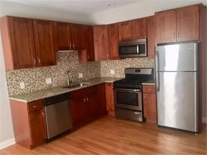 a kitchen with granite countertop wooden cabinets and stainless steel appliances