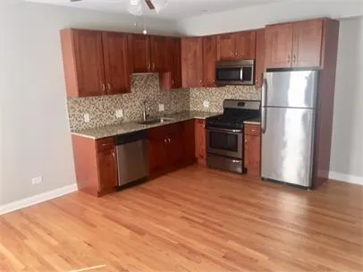 a kitchen with stainless steel appliances granite countertop a refrigerator and a stove top oven