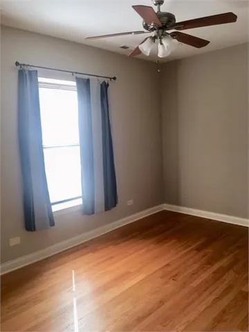 an empty room with a window and a ceiling fan