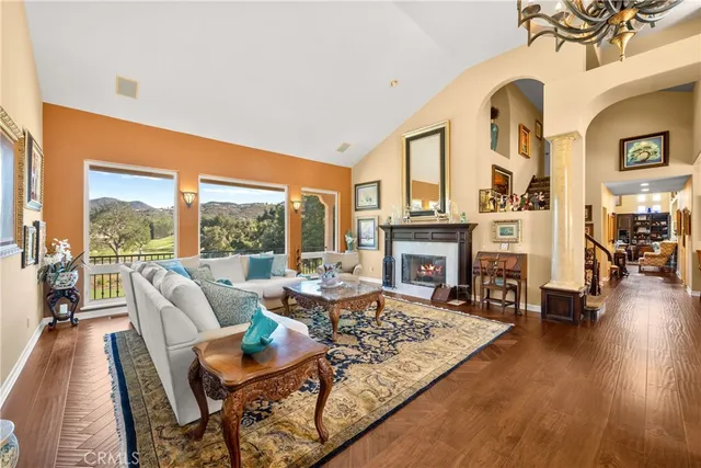 a living room with furniture large windows and wooden floor