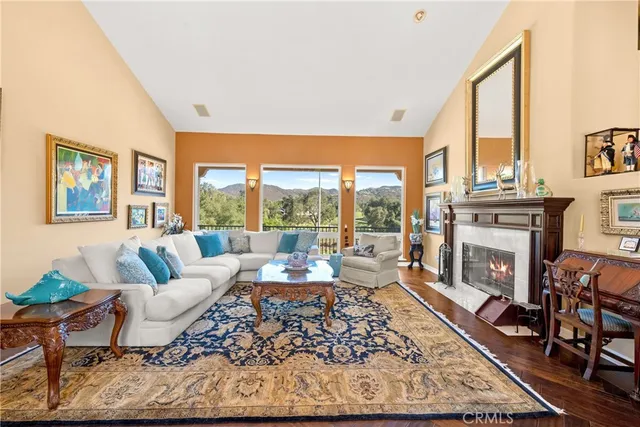 a living room with fireplace furniture and a large window