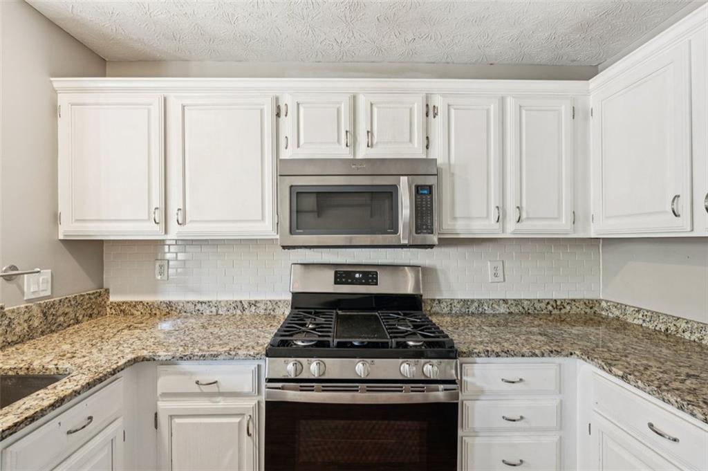2470 Jakin Way Suwanee, GA 30024 - Photo 17 of 64 a stove top oven sitting inside of a kitchen