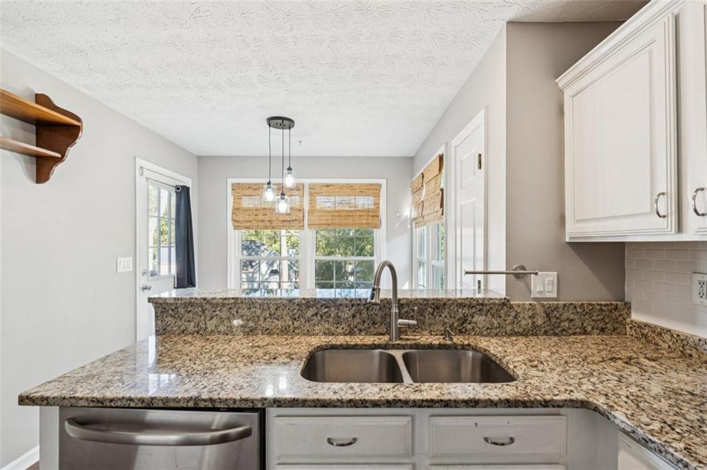 2470 Jakin Way Suwanee, GA 30024 - Photo 18 of 64 a kitchen with granite countertop a sink and a window